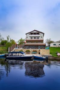 un grande edificio con barche ormeggiate in un bacino d'acqua di Pensiunea Pestisorul a Dunavăţu de Jos