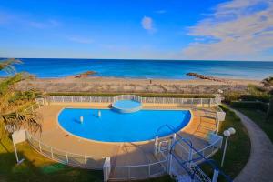 une piscine avec la plage en arrière-plan dans l'établissement T1 Cabine 4 couchages vue mer !, à Frontignan
