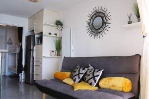 salon z kanapą z poduszkami i lustrem w obiekcie T1 Cabine 4 couchages vue mer ! w mieście Frontignan