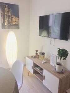 salon z telewizorem z płaskim ekranem na ścianie w obiekcie Le Casette Gargallo 1 - Ortigia w Syrakuzach