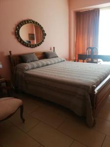 een slaapkamer met een groot bed met een spiegel aan de muur bij LA CASINA DI LAURA in Follonica