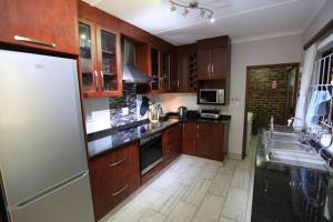 a kitchen with wooden cabinets and a white refrigerator at Pelican's Nest Holiday Home St Lucia in St Lucia