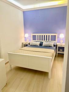 a bedroom with a large white bed with two tables at Le Casette Gargallo 1 - Ortigia in Syracuse