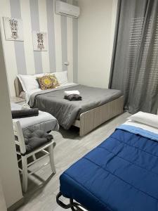 a small bedroom with two beds and a chair at Le Camere Del Villaggio in Agrigento