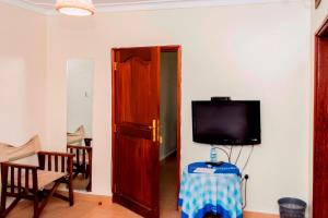 TV a/nebo společenská místnost v ubytování Kalya Courts Hotel Fort Portal