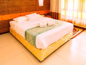 a large bed with towels on top of it in a room at Kalya Courts Hotel Fort Portal in Fort Portal