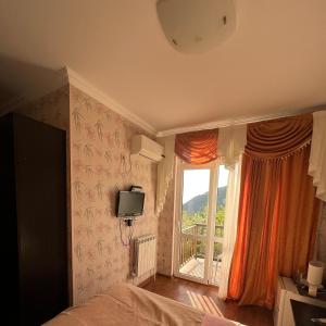 ein Schlafzimmer mit einem Bett und einem großen Fenster in der Unterkunft Гостевой дом Марина in Gagra