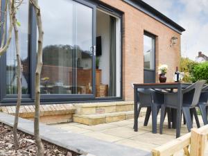 a patio with a table and chairs in front of a house at High Tide in Combe Martin