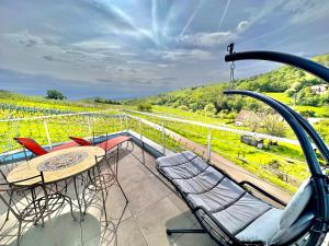 a balcony with a table and chairs and a view at Domaine BOHN Red Winehouse in Reichsfeld
