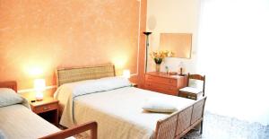 a bedroom with two beds and a dresser and a mirror at B&B Stella in Salerno