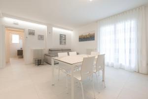 una sala da pranzo bianca con tavolo e sedie bianchi di Residence Luxury Elisabeth a Caorle