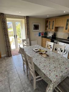 a kitchen with a table and chairs and a kitchen with a table and a table at Oakbank Farm in Lamlash