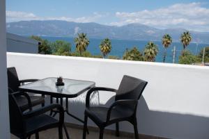 una mesa y sillas en un balcón con vistas al océano en Billys apartment Selianitika, en Selianitika