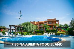 una piscina en un complejo con sillas y un edificio en Montemar Natura Resort, en Peñíscola