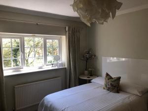 um quarto com uma cama e uma janela em Room in Twemlow Green em Goostrey
