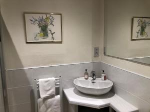 a white bathroom with a sink and a mirror at Room in Twemlow Green in Goostrey