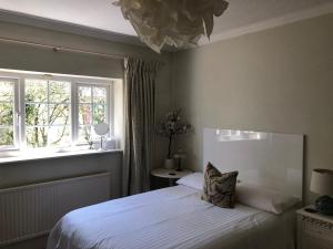 een slaapkamer met een wit bed en een raam bij Room in Twemlow Green in Goostrey