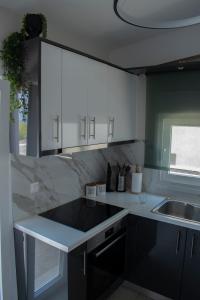 una cocina con armarios blancos y fregadero en Billys apartment Selianitika, en Selianitika