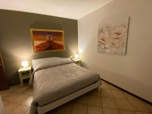 een slaapkamer met een bed en twee lampen aan de muur bij La Casa di Mimì in Foligno