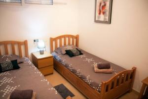 - une chambre avec 2 lits jumeaux et une table de nuit dans l'établissement Het Luxe Penthouse Sunset is PUUR genieten !, à Alhama de Murcia