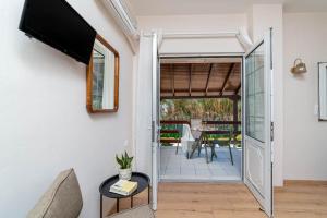 a living room with a tv and a door to a patio at Troulis Seaside in Amoudara Herakliou