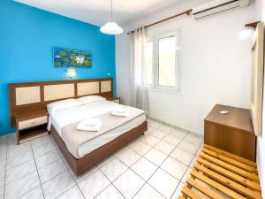 a bedroom with a bed and a blue wall at Troulis Seaside in Amoudara Herakliou