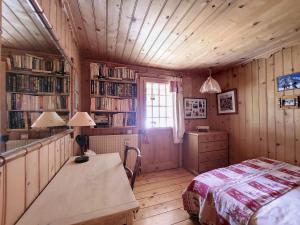 1 dormitorio con cama, escritorio y estanterías de libros en Chalet Ardent Montriond 8 personnes, en Montriond