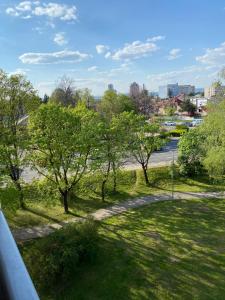 uma vista para um parque com árvores e uma rua em City Apartment em Piešťany