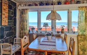 a dining room with a table and views of the ocean at Nice Home In Mellerud With 3 Bedrooms in Mellerud