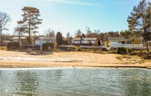 un groupe de maisons sur la rive d'une plage dans l'établissement Nice Home In Mellerud With 3 Bedrooms, à Mellerud