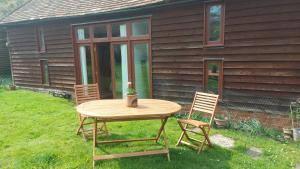 einen Tisch und zwei Stühle vor einem Haus in der Unterkunft Brooklands Barn in Lower Swanwick