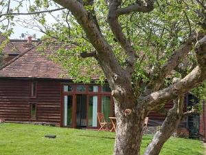 una casa con un árbol en el patio en Brooklands Barn en Lower Swanwick