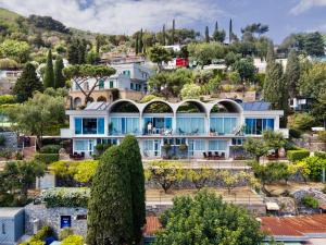 a house on top of a hill with trees at Baba Residences in Alassio