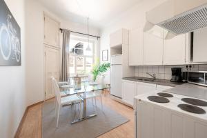 a kitchen with a glass table and white cabinets at 2ndhomes 1BR Apartment in the Center of Helsinki in Helsinki
