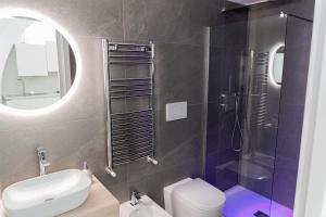 bagno con lavandino, servizi igienici e specchio di Apartment - White Place - Affitti Brevi Italia a Manfredonia