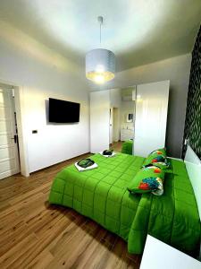 um quarto com uma cama verde e uma televisão de ecrã plano em I MORI G&G em Augusta