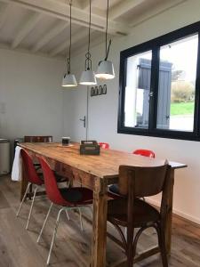 drewniany stół z czerwonymi krzesłami w pokoju w obiekcie Villa vue exceptionnelle sur le Cap Gris-Nez w mieście Audinghen