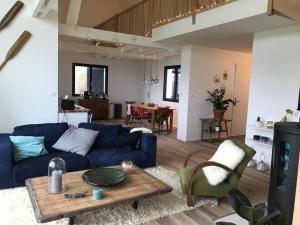 salon z niebieską kanapą i stołem w obiekcie Villa vue exceptionnelle sur le Cap Gris-Nez w mieście Audinghen