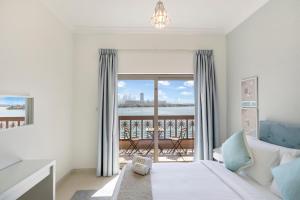 - une chambre avec un lit et une vue sur un balcon dans l'établissement FAM Living - Beach Escapes in Palm Jumeirah, à Dubaï
