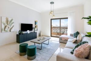 - un salon avec un canapé et une télévision dans l'établissement FAM Living - Sarai Apartments - Private Beachfront Escape in Palm Jumeirah, à Dubaï