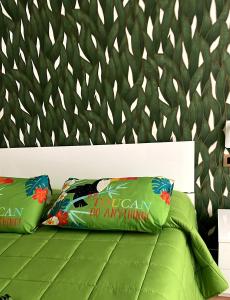 uma cama verde com duas almofadas verdes em I MORI G&G em Augusta