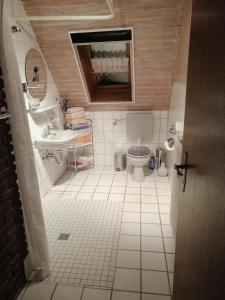 małą łazienkę z toaletą i umywalką w obiekcie Haus Weda w mieście Krummhörn