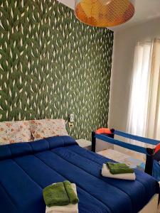 a bedroom with a blue bed and a green wall at I MORI G&G in Augusta