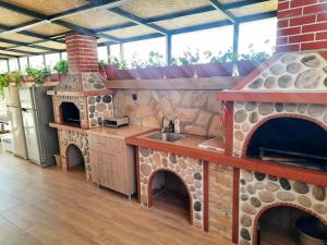een keuken met een buitenkeuken en een buitenoven bij Perla in Dospat
