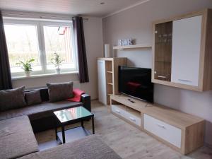 a living room with a couch and a flat screen tv at Ferienhaus Eggers in Bispingen