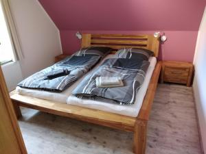 a bedroom with a wooden bed with two pillows at Ferienhaus Eggers in Bispingen