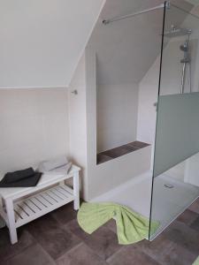 a bathroom with a glass shower with a bench at Ferienhaus Eggers in Bispingen