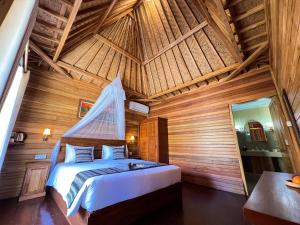 um quarto com uma cama num quarto de madeira em Skywatch cottage em Klungkung