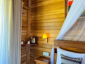 1 dormitorio con 1 cama con pared de madera en Skywatch cottage en Klungkung