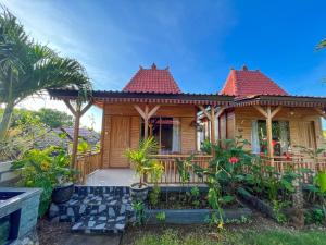 a wooden house with a porch with plants at Skywatch cottage in Klungkung